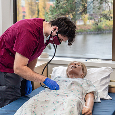 An SPU nursing student completes and exercise with a medical dummy