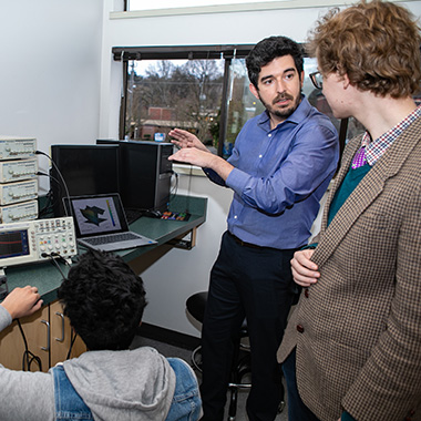 Professor Yuri Rodrigues instructs two engineering students