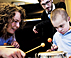 Students helping a boy using music therapy