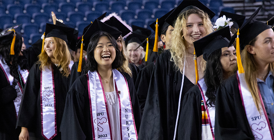 students walking in their cap and gown at SPU